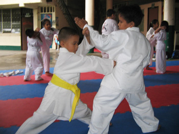 Bambini eseguono tecnica di karate